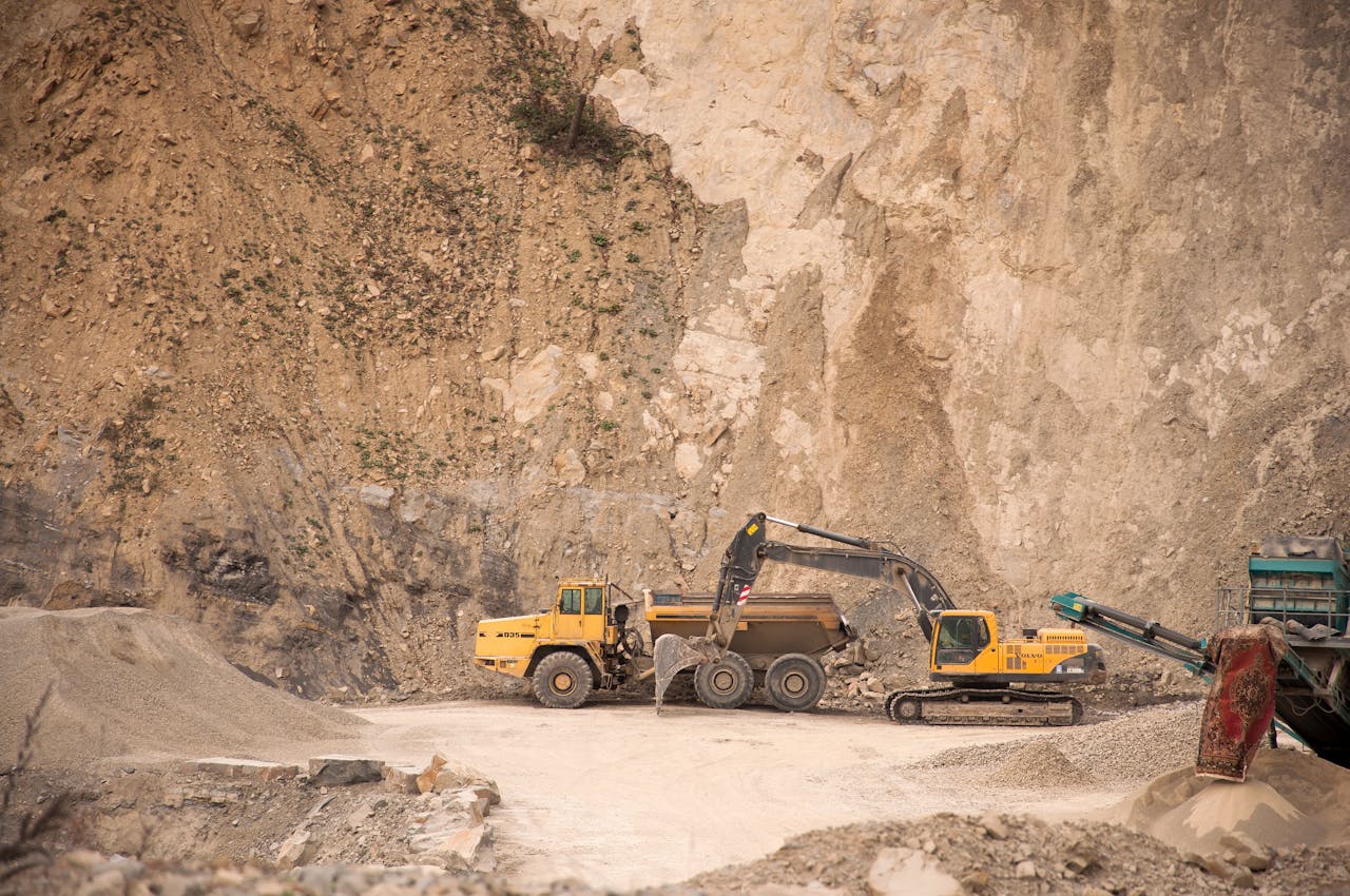 Excavator near industrial machines in quarry
